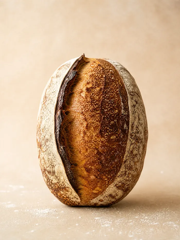 Rundt surdeigsbrød med mørk skorpe