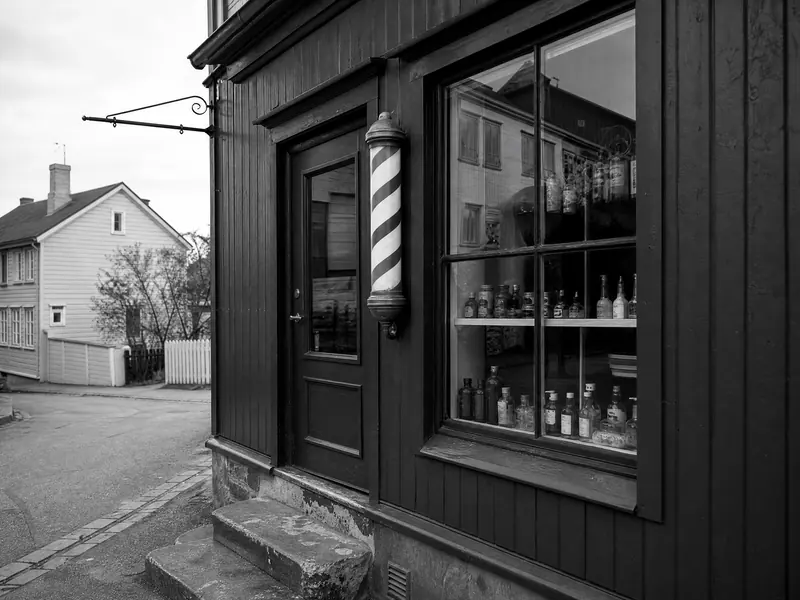Fasaden til barberstuen med høyt vindu og slitt steintrapp