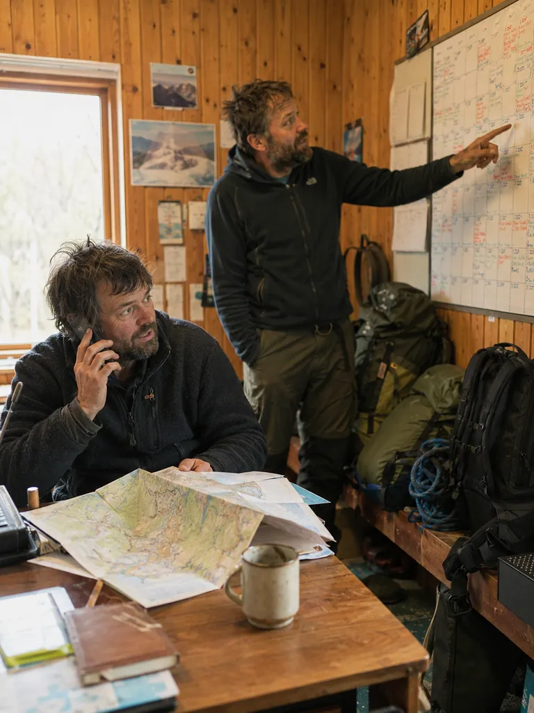 To ansatte planlegger turer på kontoret med kart og kalender