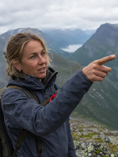 Guide på en rygg peker utover dalen
