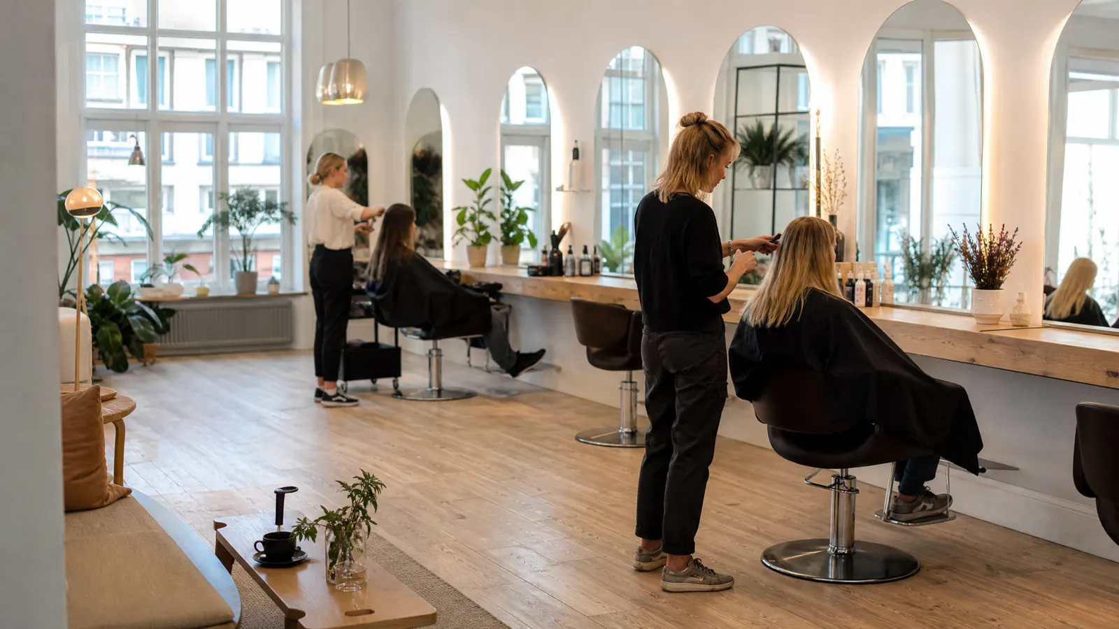 Oversiktsbilde av salongen med to frisører i arbeid ved hver sin stol